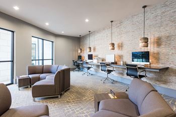 a room with couches chairs and a desk with a computer